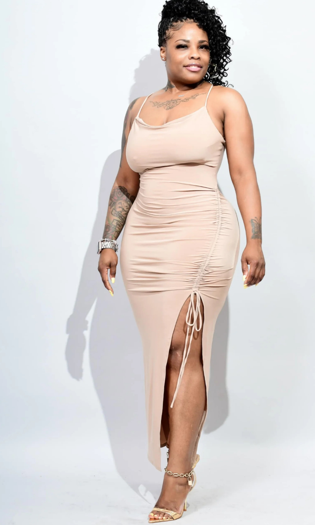 Woman wearing fitted sleeveless maxi dress with deep V-neckline and sleek silhouette, posed facing forward.