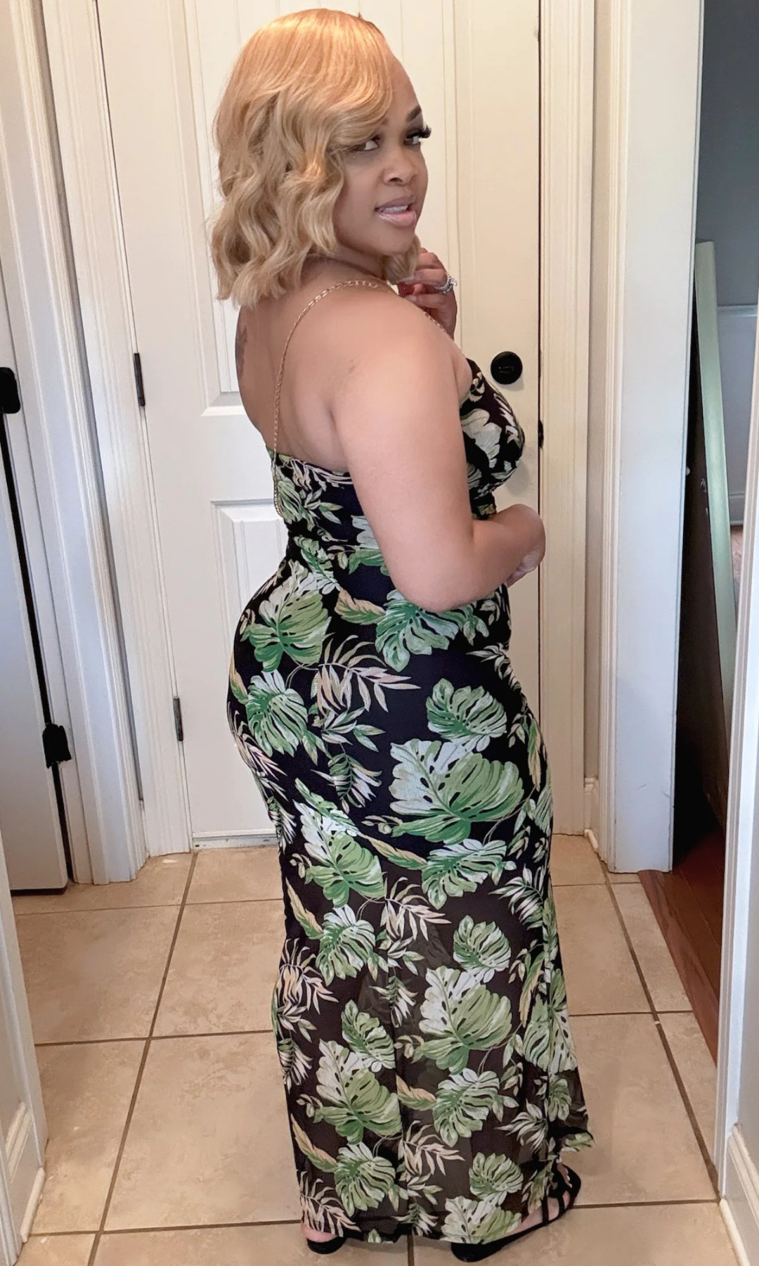 Woman wearing a floral dress standing in a room with tiled floor and white walls. Classy Summer Black so classy and classic!
