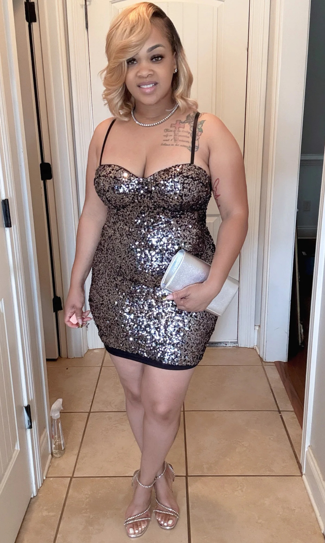 Woman wearing a sequin dress in a room with tiled floor and white walls.