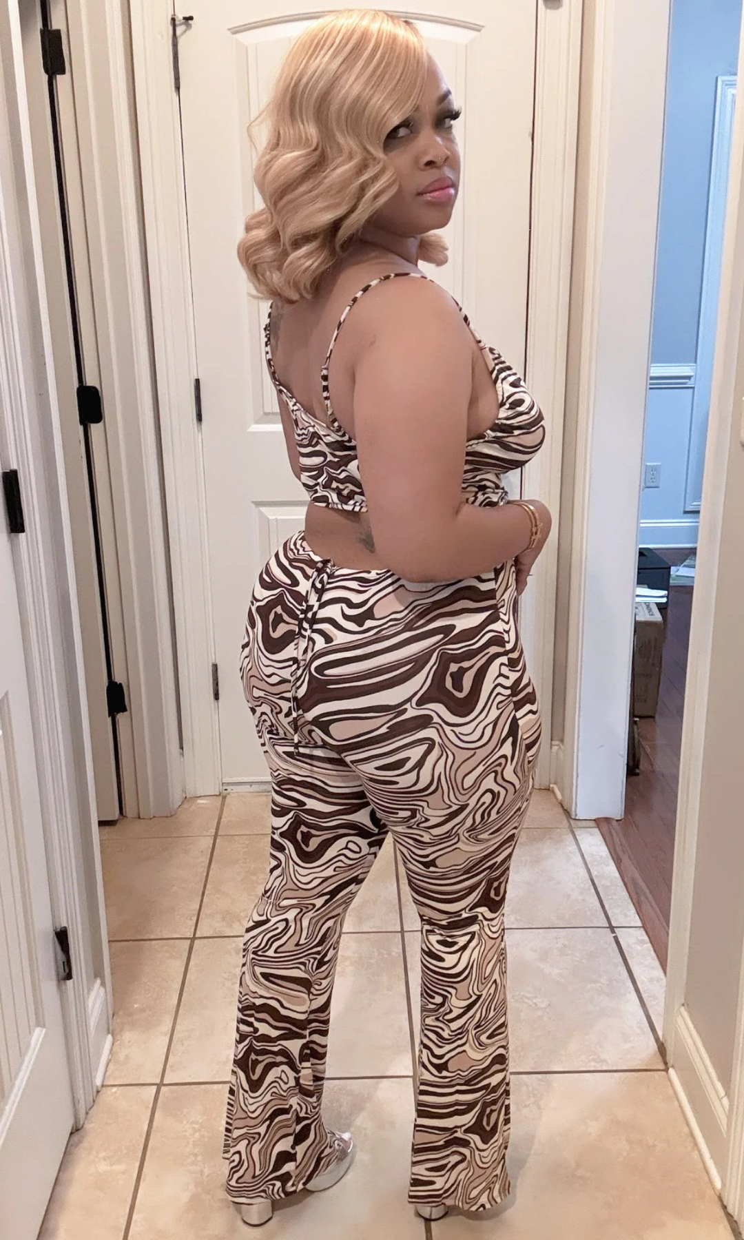 Back view of the Kingdom Set highlighting the curve-hugging flare pants and striking swirl print.