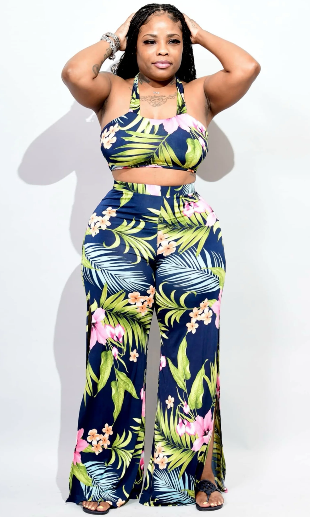 Woman wearing a tropical print two-piece outfit on a white background