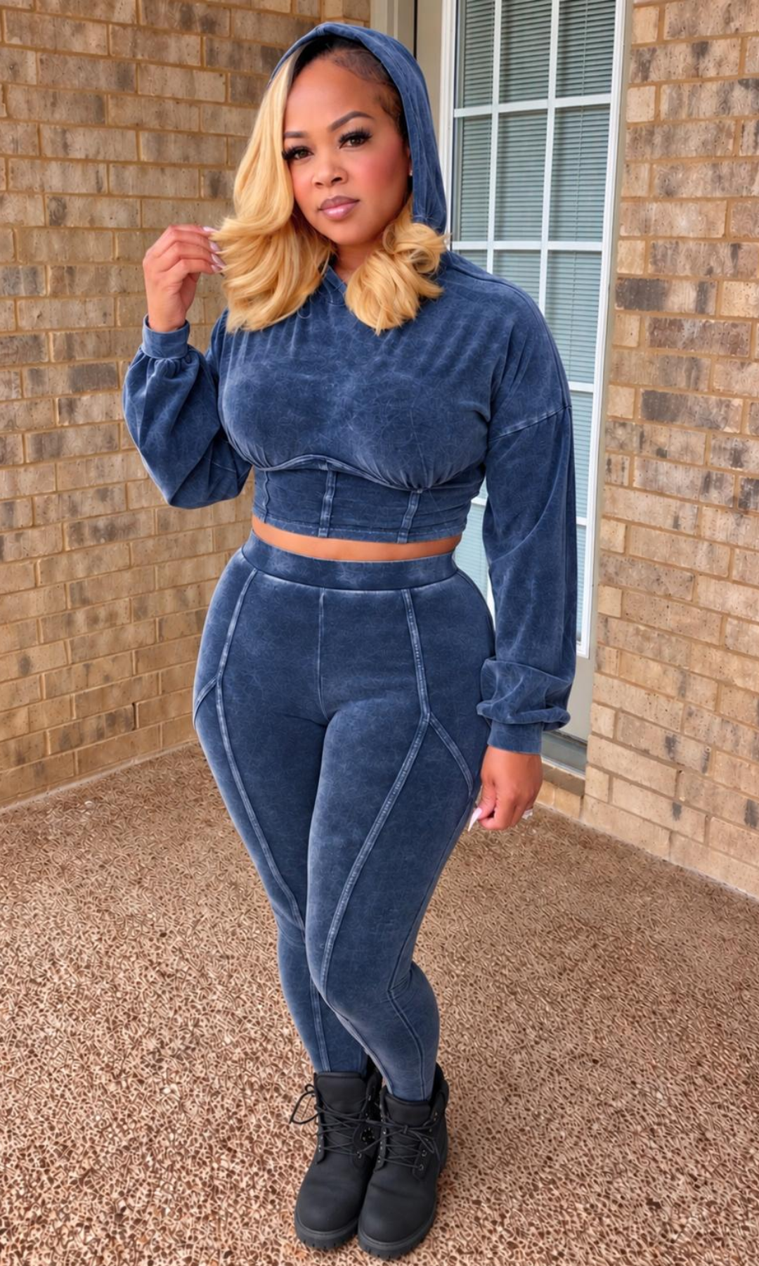 Woman modeling The Catch Blue Two-Piece Set featuring a washed blue cropped pullover hoodie with a structured waistband and matching high-waisted leggings with curved seam detailing.