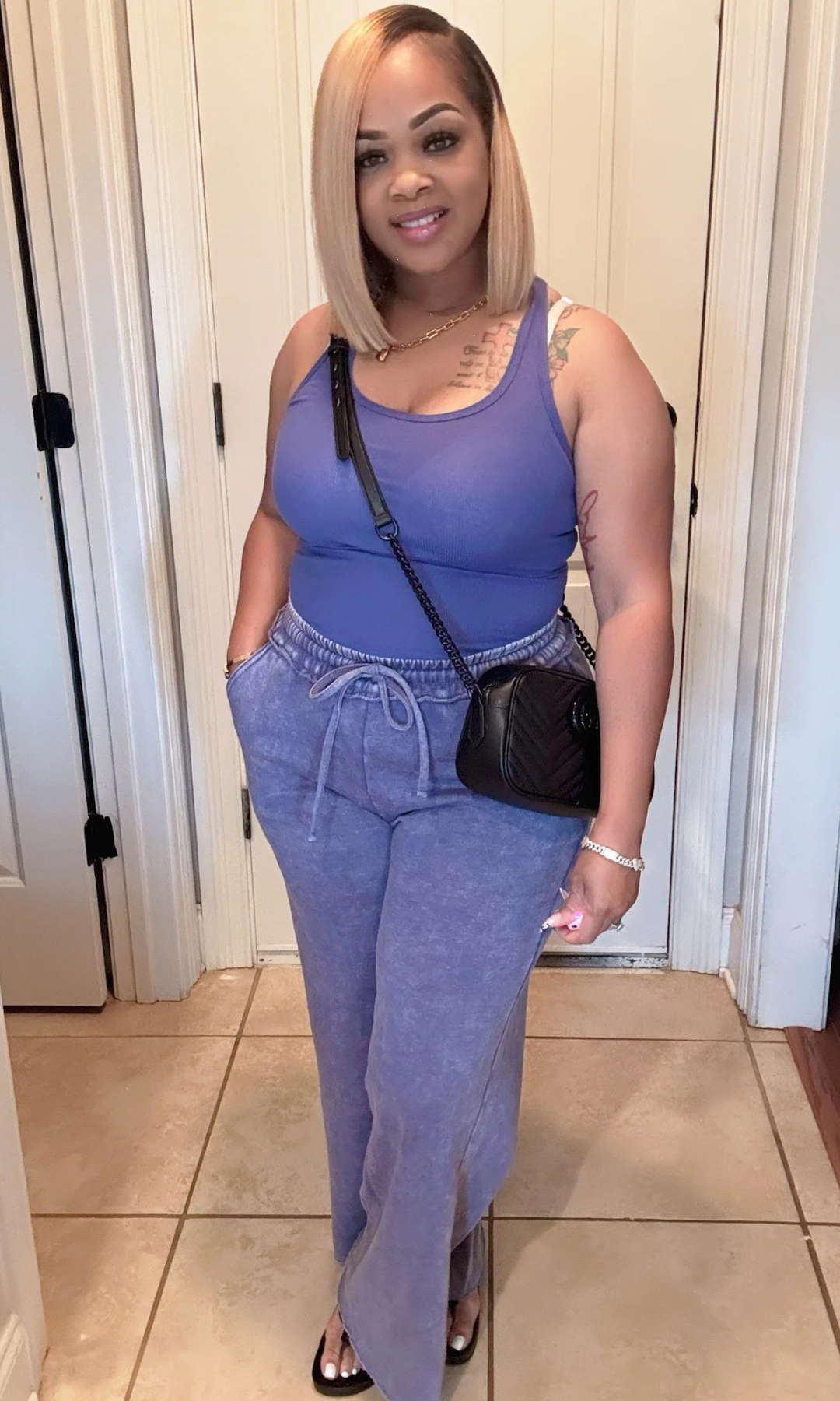 Front pose of model in washed blue tank and pants set with hands in pockets.