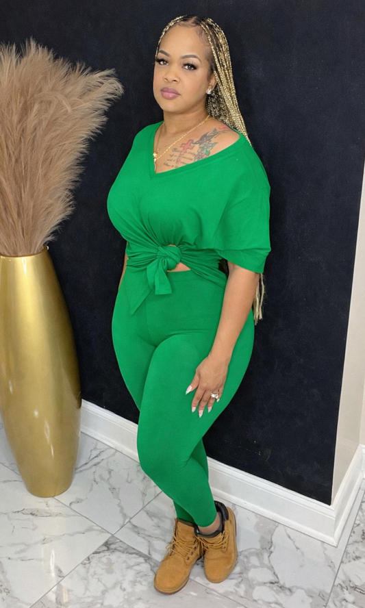 Model wearing Basic Set Kelly Green in size medium, front view styled with boots, featuring high-waisted leggings and knotted top detail.