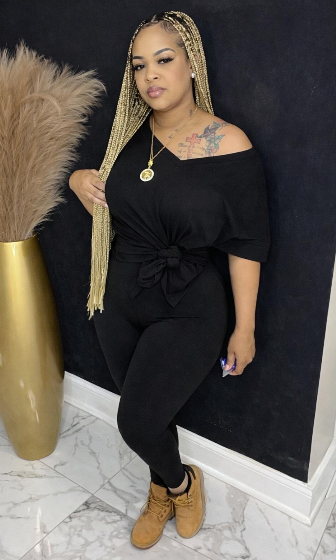 Model wearing Basic Set Black in size medium, front view styled with boots, featuring high-waisted leggings and knotted top detail.