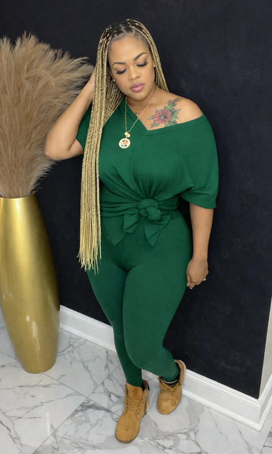 Model wearing Basic Set Hunter Green in size medium, front view styled with boots, featuring high-waisted leggings and knotted top detail.