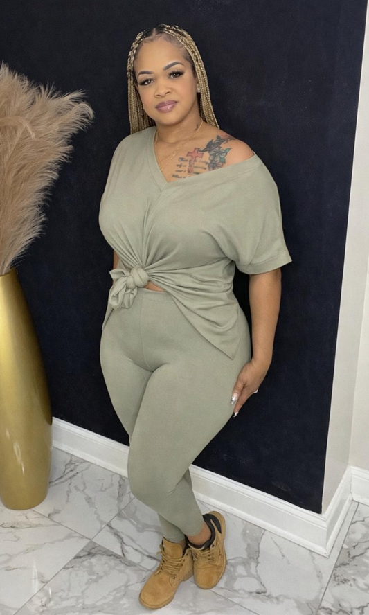 Model wearing Basic Set Light Olive in size medium, front view styled with boots, featuring high-waisted leggings and knotted top detail.