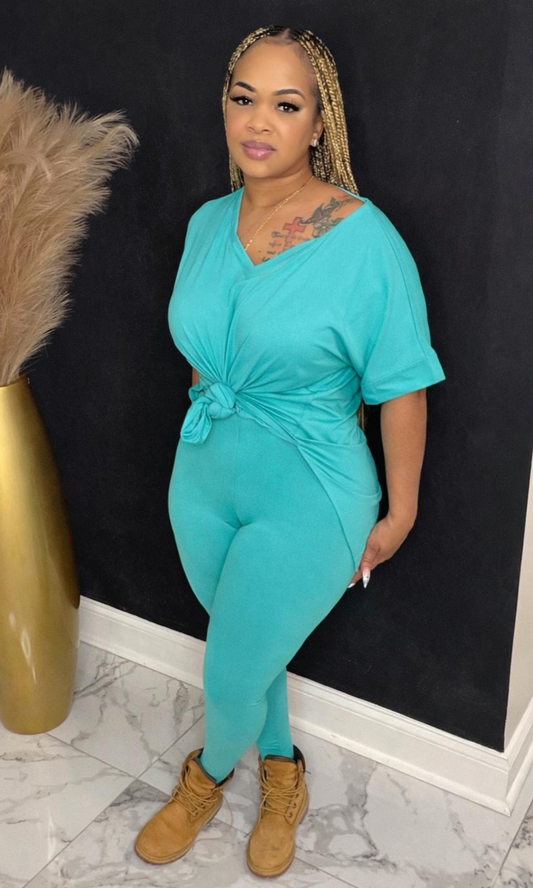 Model wearing Basic Set Turquoise in size medium, front view styled with boots, featuring high-waisted leggings and knotted top detail.