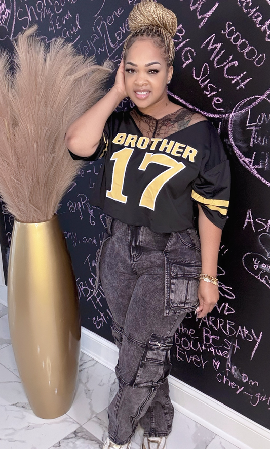 Black Acid Cargo Jeans – Front View – Woman wearing black acid wash cargo jeans with pocket details, styled with a cropped top.