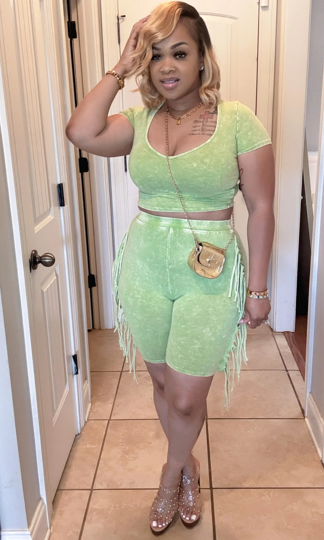 Woman posing in green two-piece fringe set with side fringe detail.