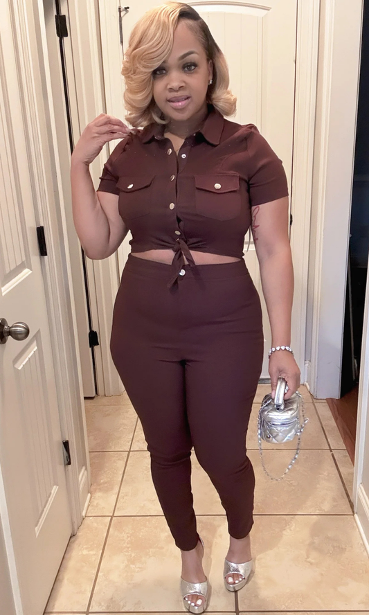 Woman wearing a brown outfit with a cutout design, standing in a room.