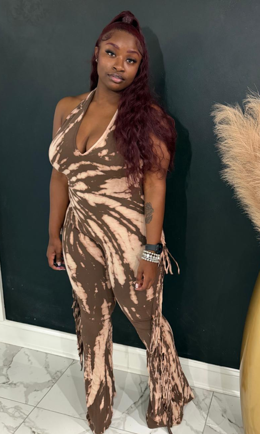 Woman wearing the Brown Tie Dye halter jumpsuit with fringe side details and flared legs.
