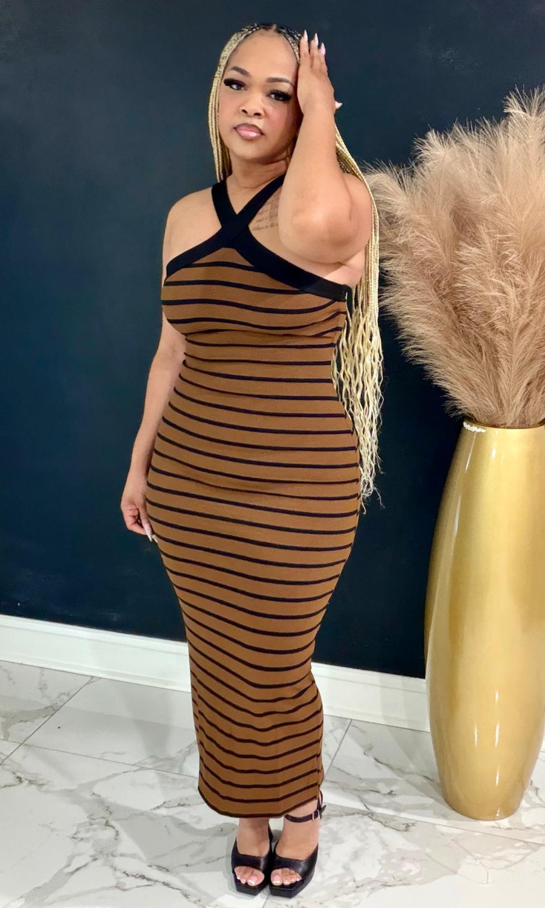 Woman wearing the Brownie striped bodycon maxi dress with a crisscross halter neckline and flattering fitted silhouette.