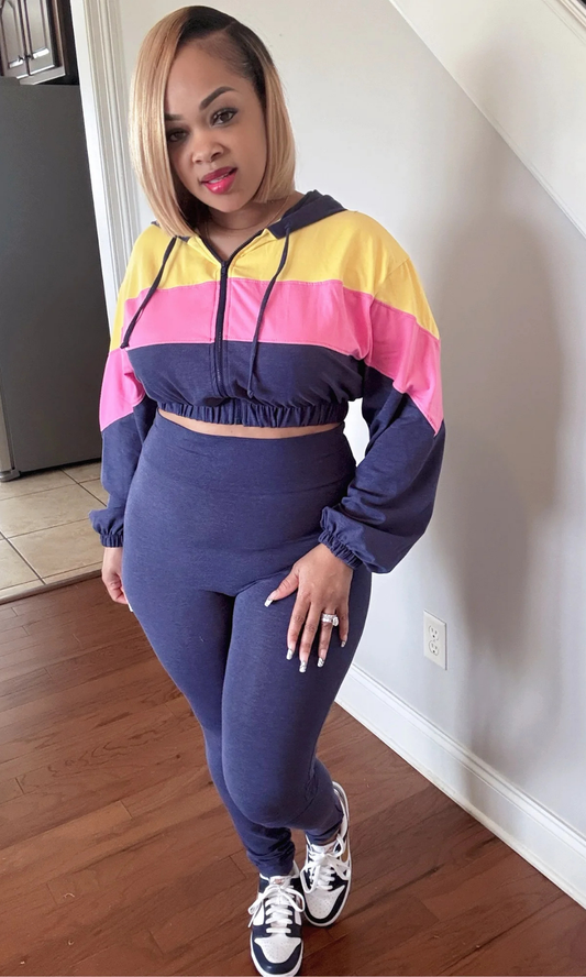 Woman wearing a colorful COLOR CRAZY 2-piece tracksuit standing in a room with wooden flooring.
