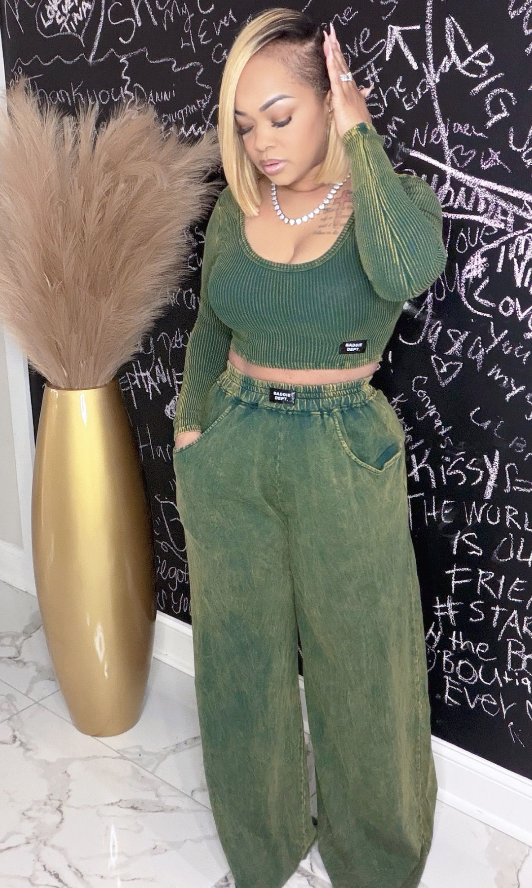 Woman wearing Envy Unbothered Set with ribbed green crop top and wide-leg pants, front view