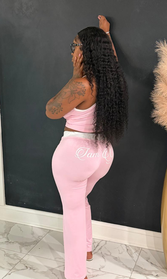 Woman wearing the Gia Active Wear pink two-piece set featuring a cropped tank and high-waisted flare pants with white side stripes.