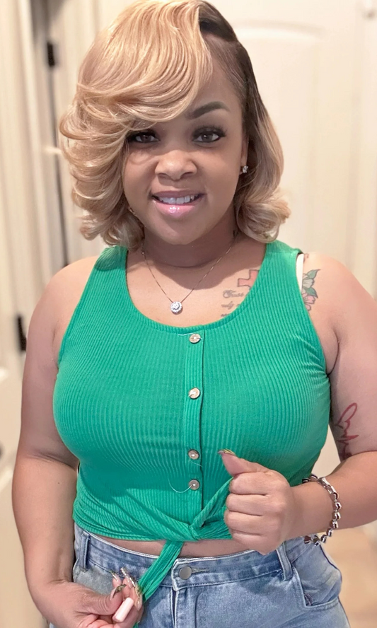 Woman wearing green ribbed crop top with button front and tie hem, close-up view.