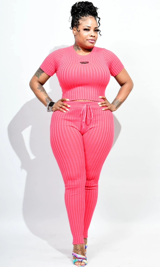 Person wearing a bright pink ribbed outfit on a white background