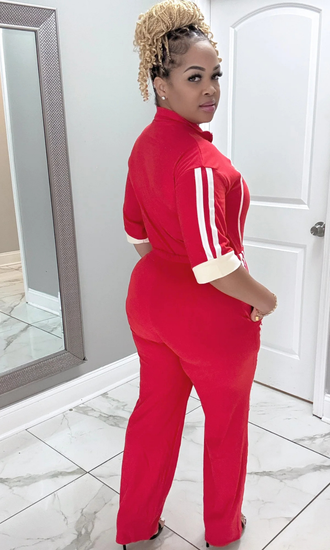 Back view of It’s Bad Red jumpsuit in vibrant red with cuffed sleeves.