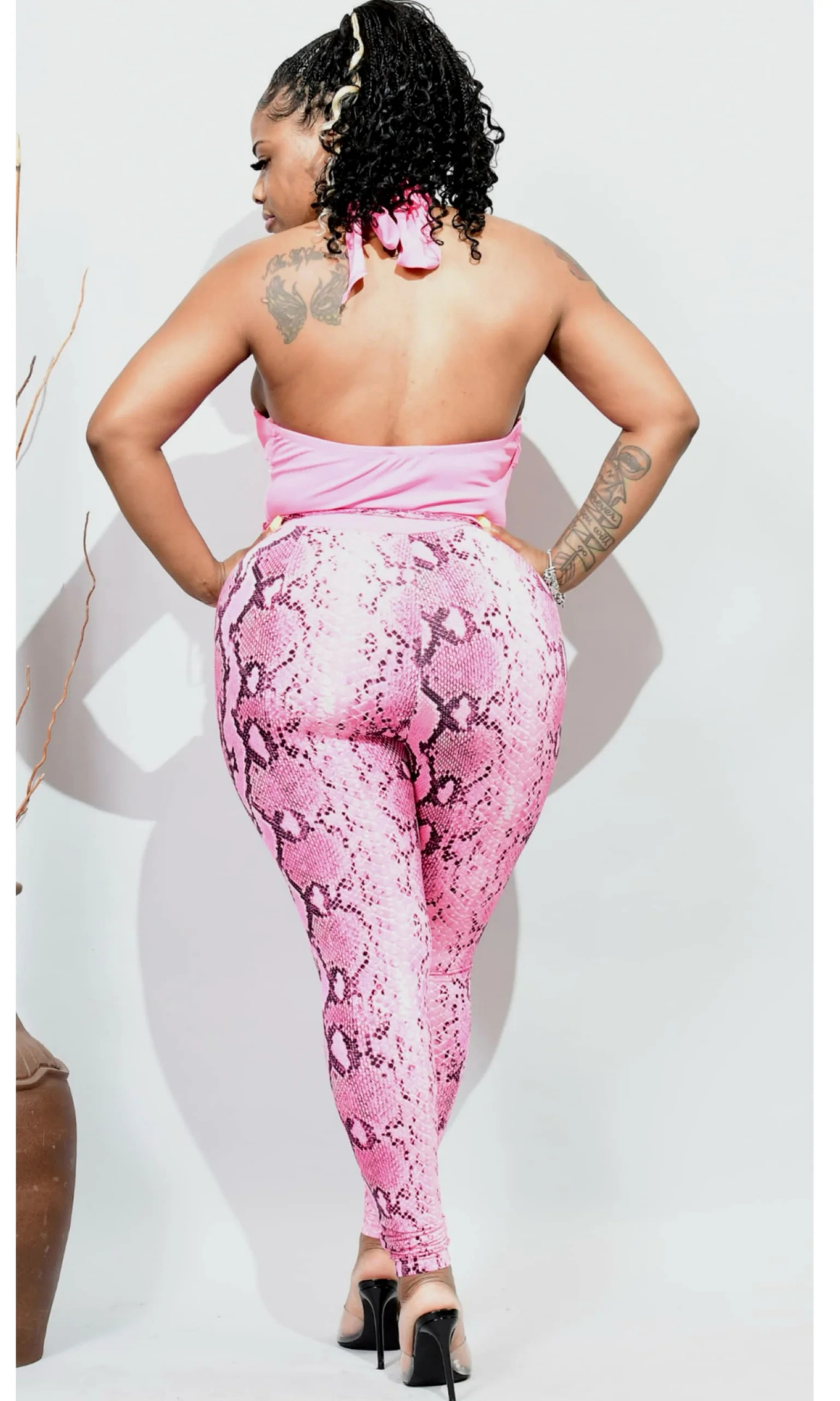 Back view of pink snakeskin jumpsuit with open halter back