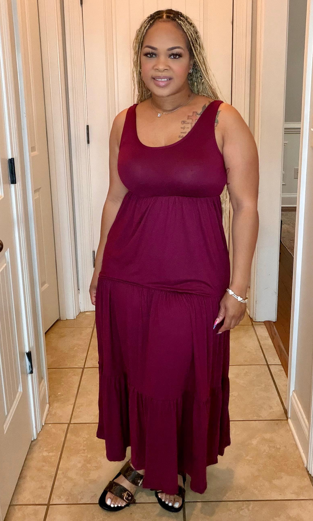 Woman wearing a burgundy dress standing in a hallway.
