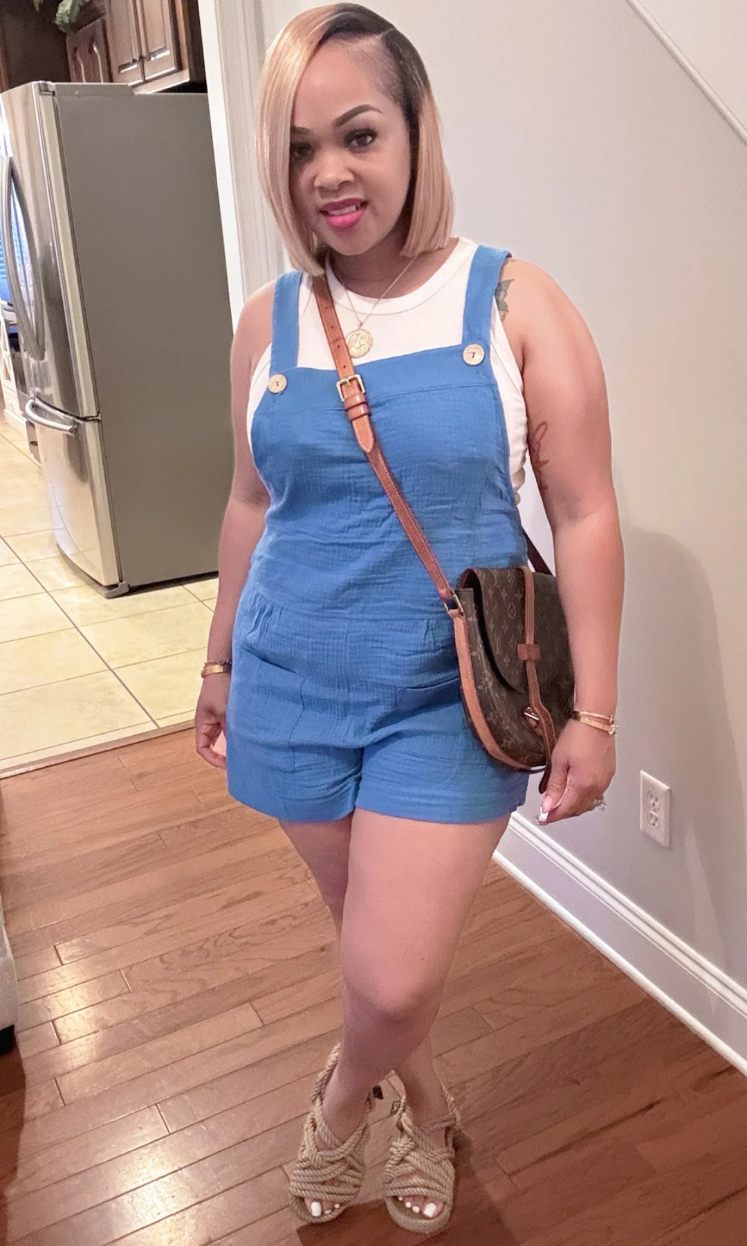 Front view of Rachel Jumpsuit in sky-blue with button-strap detail and sleeveless white top underneath.