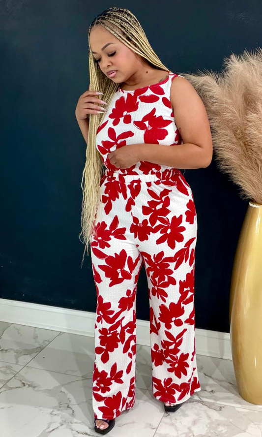 Red Garden Jumpsuit featuring a vibrant red floral print, sleeveless silhouette, and flowing wide-leg design for a fresh, elegant statement look.