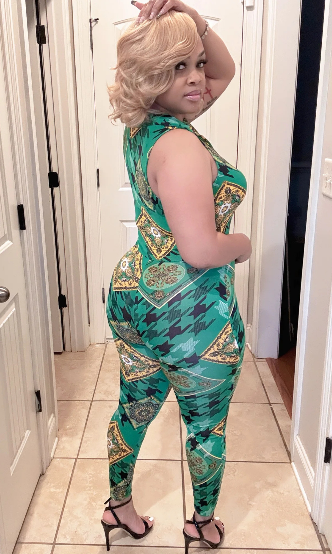Back view of woman showcasing fitted green patterned jumpsuit