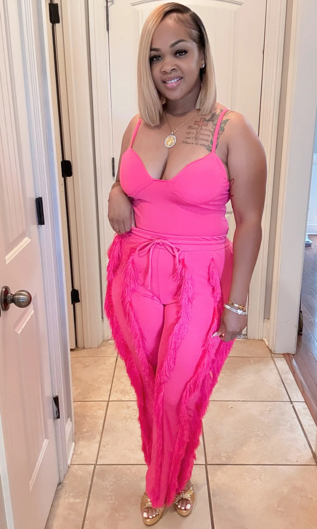 Side view of woman wearing Shimmy Pink 2-piece short set with tassel details.