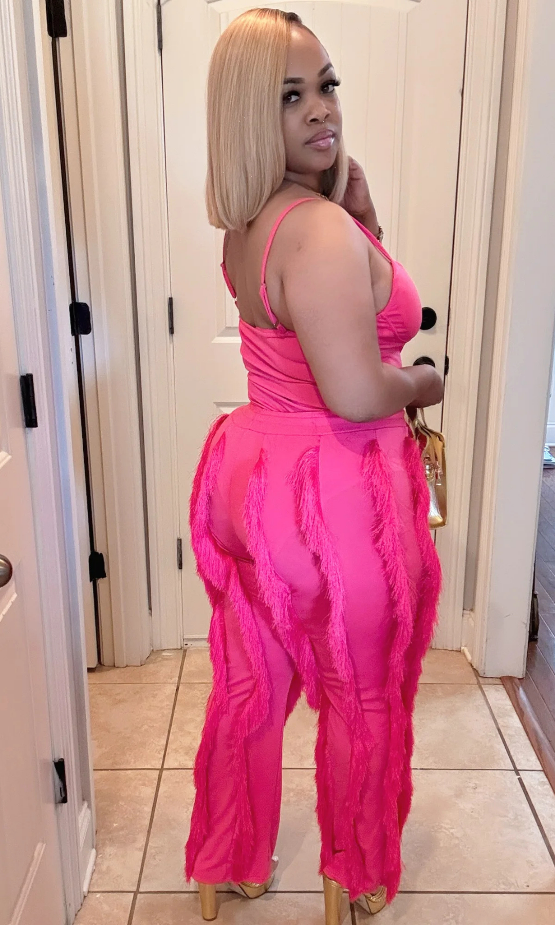 Back view of woman wearing Shimmy Pink 2-piece short set with tassel details.