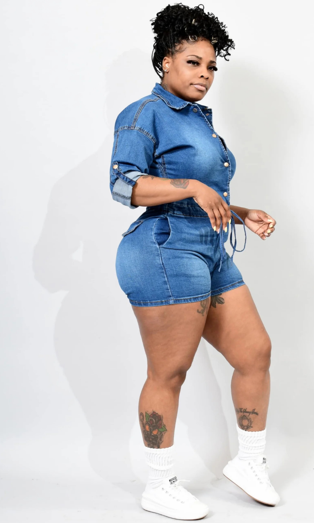 Woman wearing a denim jumpsuit side view on a white background