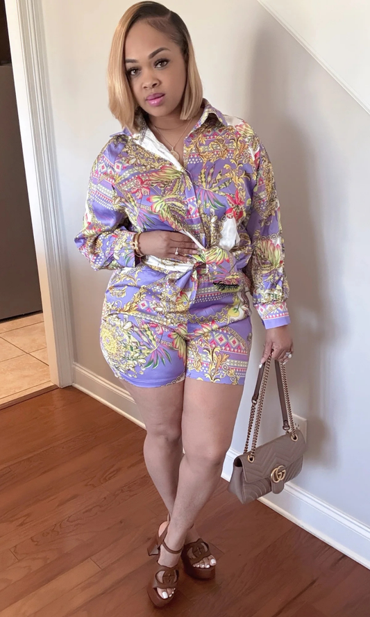 Front view of woman wearing the Spring Time 2-piece set in vibrant floral and chain print with tied shirt.