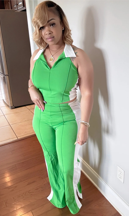 Front view of woman wearing the Strike A Pose Green 2-piece set with halter top and flare pants, featuring white side panels.