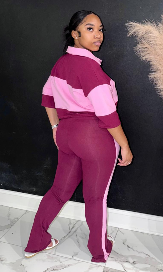 Woman wearing the Stripe Love Pink two-piece set featuring a colorblock collared crop top and high-waisted flare pants with side stripes.
