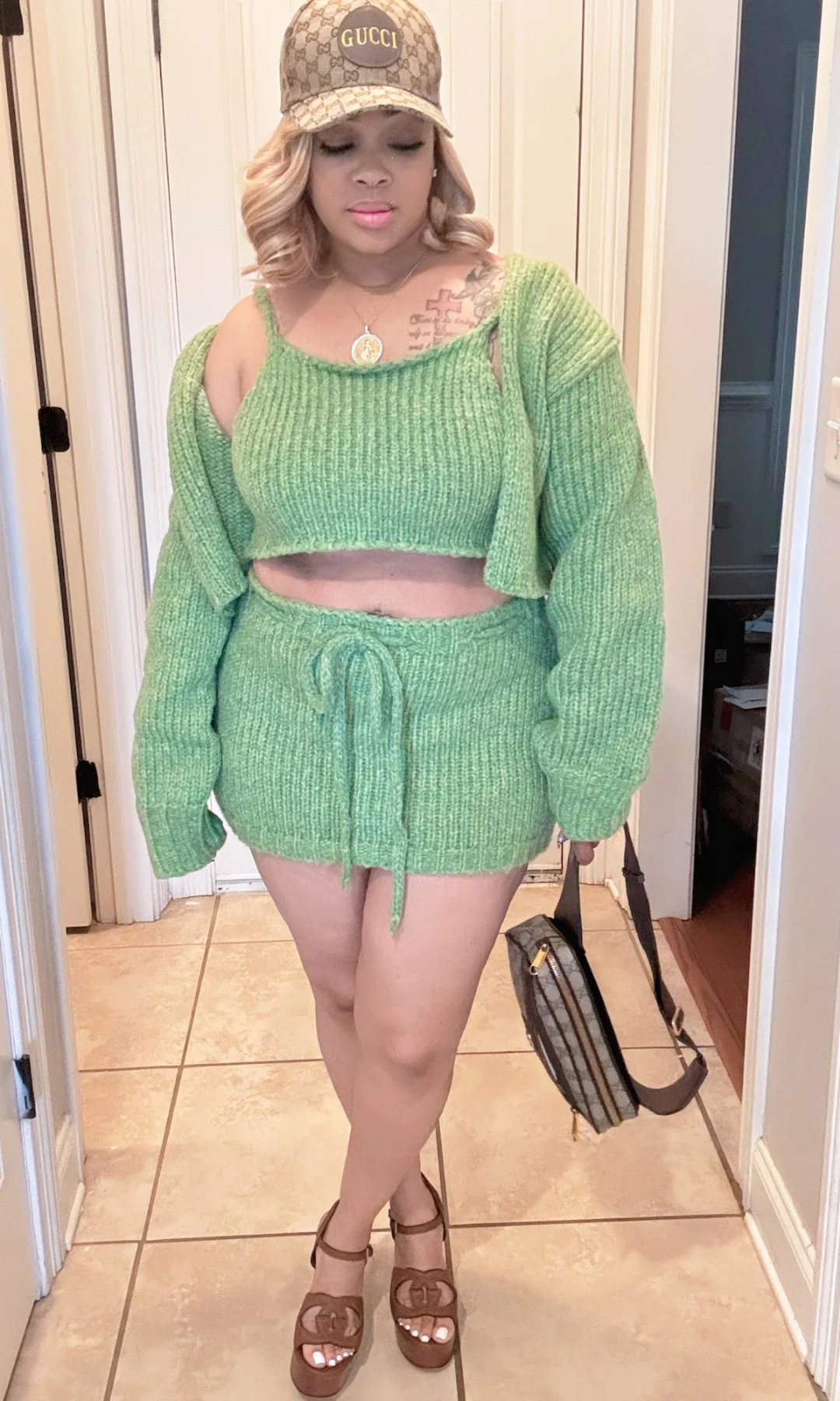 Front view of woman wearing the Style Me Green 3-piece knit set with cropped tank, cardigan, and drawstring mini skirt.