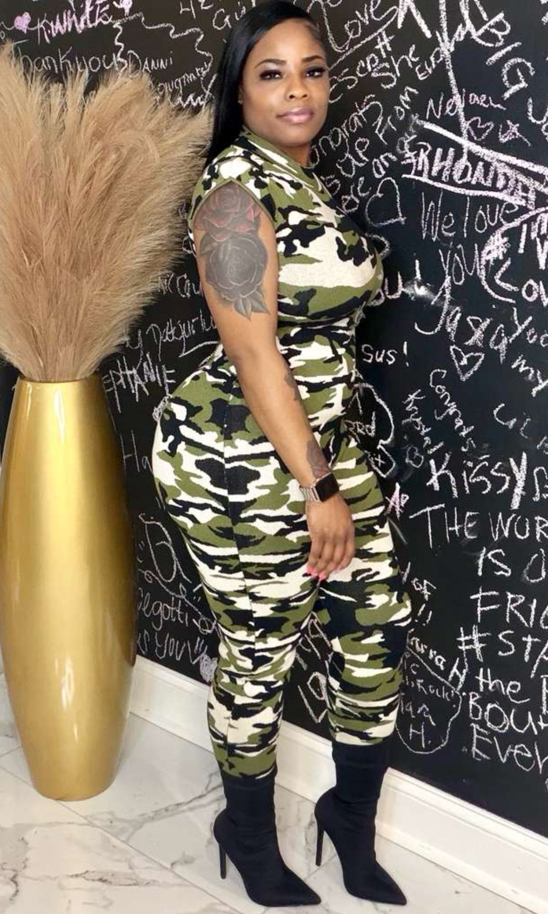 Model wearing The Camo Command Jumpsuit with sleeveless fitted design