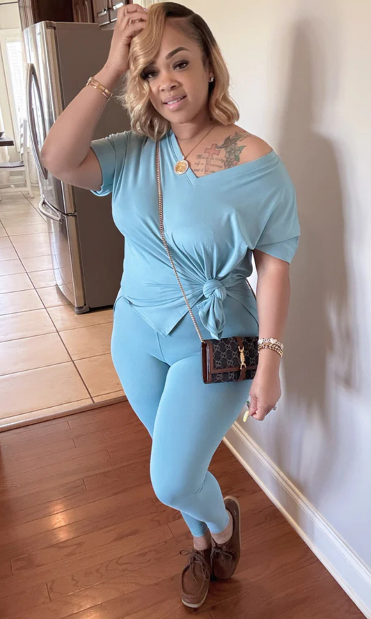 Woman in a light blue outfit standing in a kitchen.