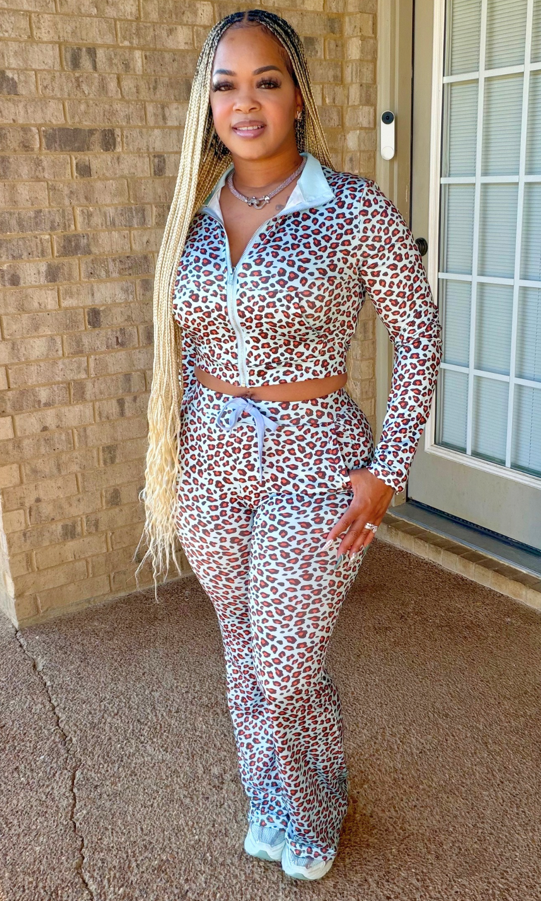 Woman wearing the Baby Blue Cheetah Jogg Set featuring a multicolored cheetah print cropped zip-up jacket and matching high-waisted jogger pants.
