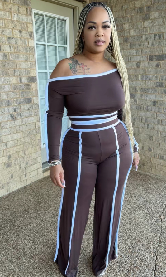 Woman modeling the Cappuccino Cutie chocolate brown two-piece set featuring a long-sleeve off-the-shoulder crop top and matching high-waisted wide-leg pants with light blue contrast piping.