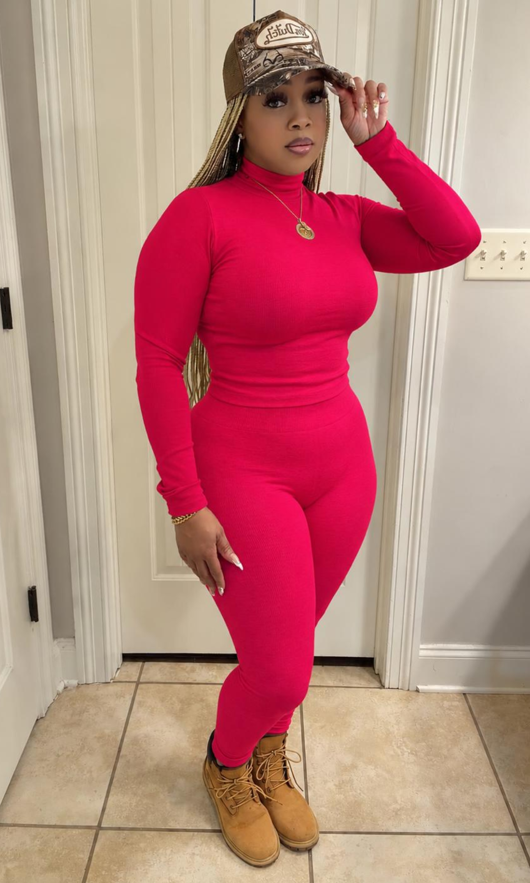 Model wearing the Ruby Turtleneck Set featuring a vibrant ruby pink long-sleeve fitted turtleneck top and matching high-waisted leggings.